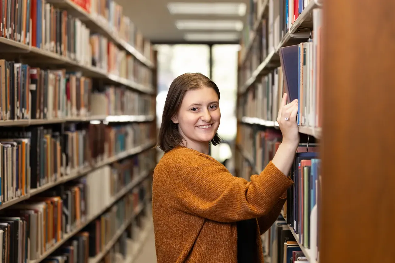 A person looking at books in a library.